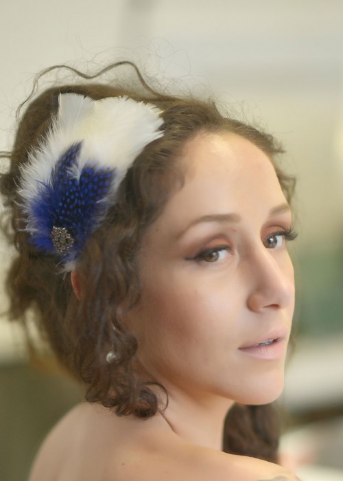 White blue headpiece with feathers and rhinestones mounted on headband 
