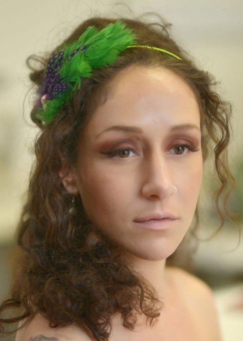 Green headpiece with feathers mounted on headband 