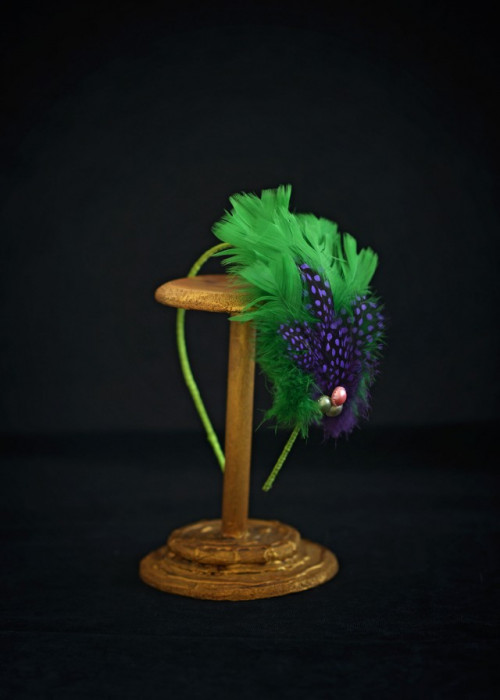 Green headpiece with feathers mounted on headband 